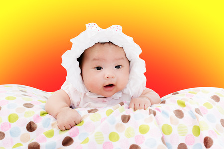 Portrait of adorable baby girl. Isolated on warm background with copy spaceの写真素材