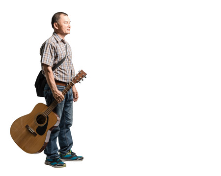 Portrait of a happy mature man standing and holding guitar. Isolated full length on white background with copy spaceの写真素材