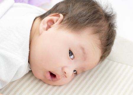 Portrait of adorable baby girl lie on the stomachの写真素材