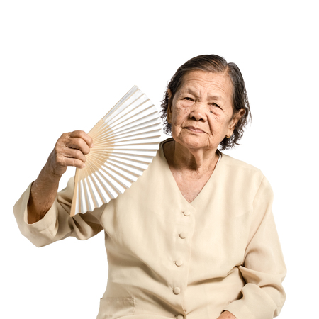 portrait of a senior woman with folding fan. Isolated on white backgroundの写真素材