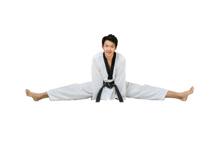 Portrait of an asian professional taekwondo black belt degree (Dan) stretching his body. Isolated full length on white background with copy space and clipping pathの写真素材