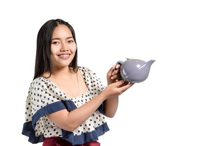 portrait of a beautiful asian woman smiling and holding tea pot in the hands. Isolated on white background with copy space and clipping pathの写真素材