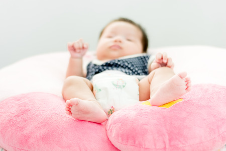 Portrait of a little adorable infant baby girl's feet  lying on backの写真素材