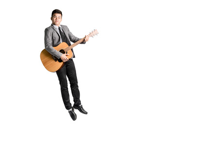 Portrait of a young business man jumping with guitar. Isolated on white background with copy space...