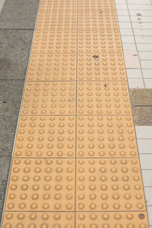 braille block tactile paving for blind handicap on tiles pathwayの写真素材