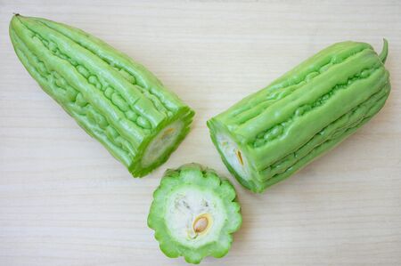 Fresh green bitter melon or Chinese Bitter Gourd on clean wooden backgroundの写真素材