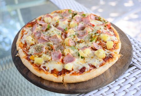 Hawaiian Pizza. Pizza topped up with pineapple, ham, onions, cheese, tomatoes, bacon,Bell pepper and sauce.の写真素材