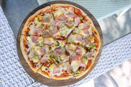 Hawaiian Pizza. Pizza topped up with pineapple, ham, onions, cheese, tomatoes, bacon,Bell pepper and sauce.  top viewの写真素材