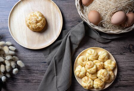 Delicious eclairs or cream puff or French profiteroles or choux dough filled with vanilla custard cream,on wooden background. top view.の写真素材