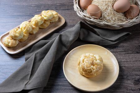 Delicious eclairs or cream puff or French profiteroles or choux dough filled with vanilla custard cream,on wooden background.の写真素材