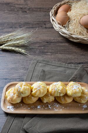 Delicious eclairs or cream puff or French profiteroles or choux dough filled with vanilla custard cream,on wooden background.の写真素材