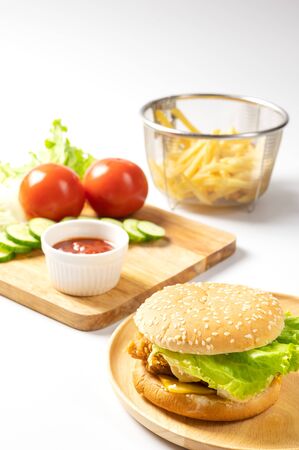 Crispy fried chicken burger on Round Wood plate served with french fries and ketchup on white background.の写真素材
