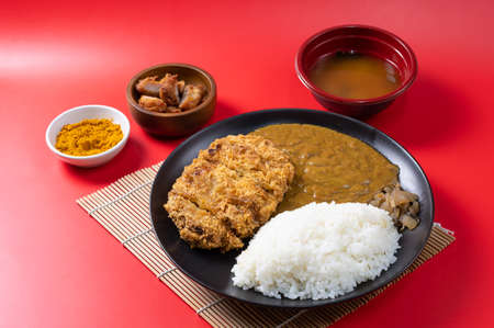 Tonkatsu Curry Rice (Japanese deep-fried pork cutlet with Curry rice) served with karaage (Japanese style fried chicken). on red background.の写真素材