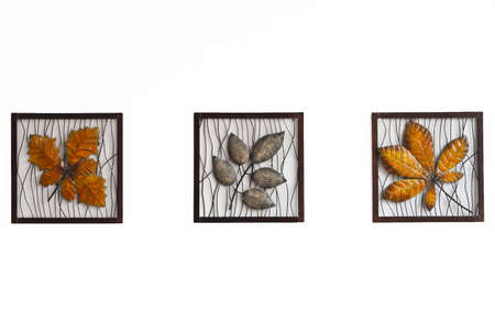 three metal leaves in the square isolated on white wall