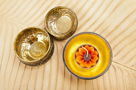 Two brass bowls and wood golden bowl on brown banana leaf
