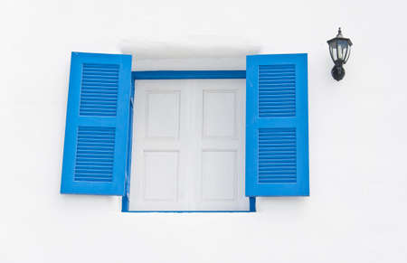 Blue wooden windows with lantern in white building