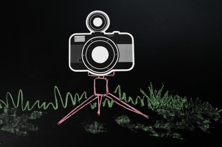 Black camera on tripod drawing by pastel on black leather sheetの写真素材