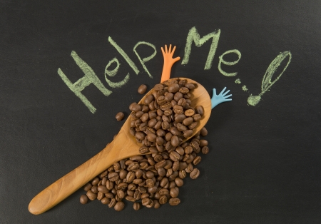 Coffee bean in wooden spoon with help me hand writingの写真素材
