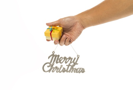 One hand holding yellow gift box and Merry Christmas signの写真素材