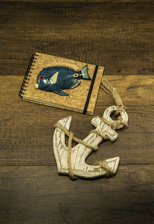 Cork cover book with blue fish and large old white anchorの写真素材