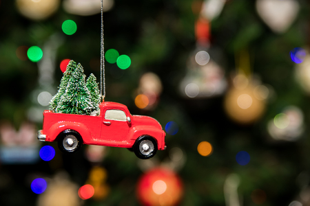Red pickup car with Christmas tree hanging on Christmas treeの写真素材