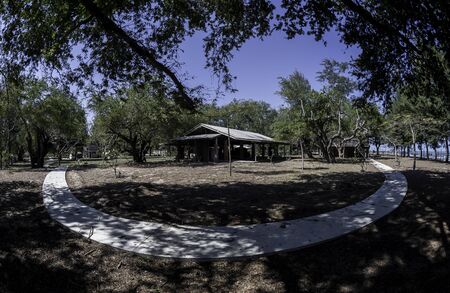 Curve pathway around the open conference room with tree and clear blue skyの写真素材