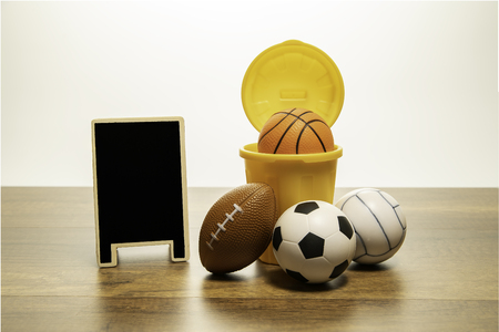 Many kind of balls and yellow basket with blank black boardの写真素材
