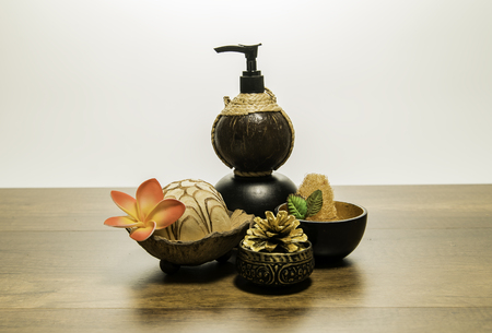 Small coconut bottle of spa with flower and golden pine coneの写真素材