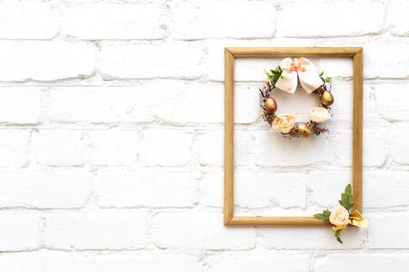 Beautiful hand made everlasting dry wreath made of dyed eggs and flowersin golg frame on the white...