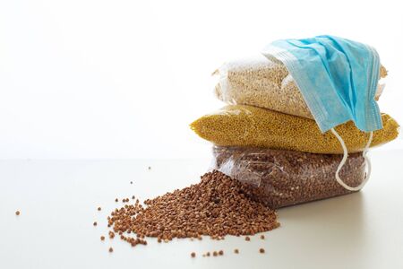 Food supply with groats and medical surgical mask during outbreak of coronavirus COVID-19....