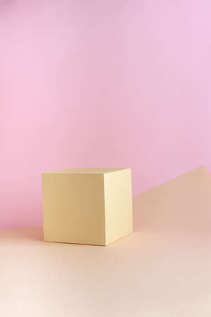 Abstract empty podium of geometric shape on pastel background for product. Beige cube on light brown and pink backdrop. Pedestal template for advertising photo. Minimal concept. Mock up.の写真素材