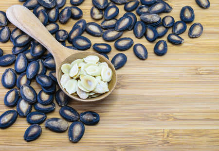 Edible watermelon seeds in wood spoon on wood backgroundの写真素材