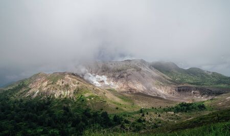 View of Mount Usu summit and fuming volcanic smoke located at the south of lake toya, hokkaido, japanの写真素材