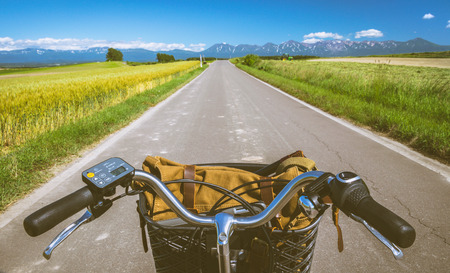 Biking through the hills and barley field in summer, Patchwork road, Biei, Hokkaido, Japan. View from bikers eyes.の写真素材
