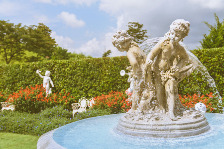 Close up of Young sculpture and fountain in English garden, Vintage styleの写真素材