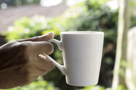 Young man drinking coffee from cupの写真素材