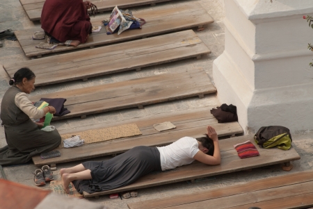 KATHMANDU,NEPAL- MARCH 15  Tibetan pilgrim circles the holy Boudhanath stupa on March 15, 2012 in Kathmandu, Nepal  Here a devotee performs full body prostration for an entire day のeditorial素材