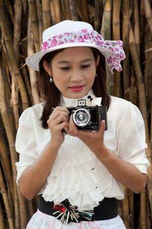 Pretty Asian woman use vintage camera in bamboos forest  の写真素材
