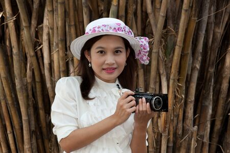 Pretty Asian woman use vintage camera in bamboos forest  の写真素材