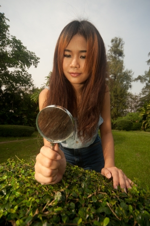 Pretty Asian woman with magnifying glass  の写真素材