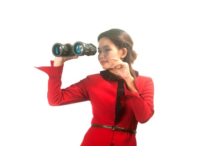 Pretty Asian business woman in red suit looking with binoculars on white background  の写真素材