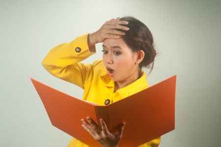 Pretty young Asian businesswoman in yellow suit is shocked and surprised  の写真素材