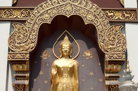 Basrelief standing golden Buddha at wall church in Thai temple 