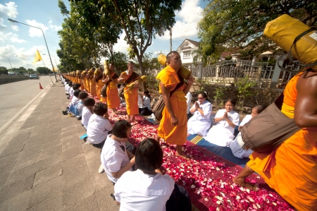 Bangkok,Thailand-January 21,2012   Row of Buddhist hike Thai monks on streets strewn with rose petals on the Thammachai hike establish the path of the great teachers on January 21,2012 in Bangkok , Thailand のeditorial素材