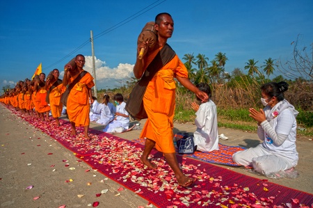 Bangkok,Thailand-January 21,2012   Row of Buddhist hike Thai monks on streets strewn with rose...