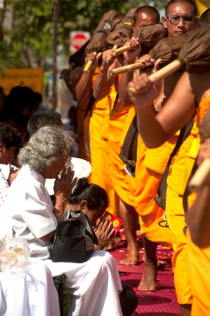 Bangkok,Thailand-January 21,2012   Row of Buddhist hike Thai monks on streets strewn with rose petals on the Thammachai hike establish the path of the great teachers on January 21,2012 in Bangkok , Thailand のeditorial素材