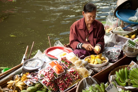 Ratchaburi,Thailand - July 21, 2013  A woman selling fruit from her boat at Damnuan Saduak floating market in Thailand  The Market is held everyday until noon and has become very popular with tourists visiting from Ratchaburi Province,Middle of Thailand のeditorial素材