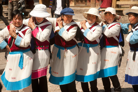 LIJIANG,CHINA-MARCH 17  A groups of Naxi nationality old women dressed in traditional clothing dancing Located in Dayan Old Town Squre street   Sifang Square   on March 17,2014 in Lijiang,Yunnan province,Southwestern of China のeditorial素材