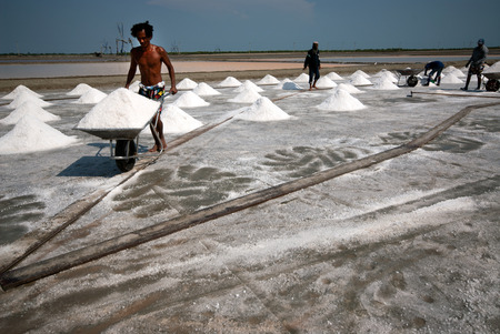Workers are working at a salt farm in Thailand.