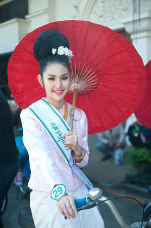 Pretty woman in traditional dresses ride a bicycle parade show in Umbrella Festival .のeditorial素材
